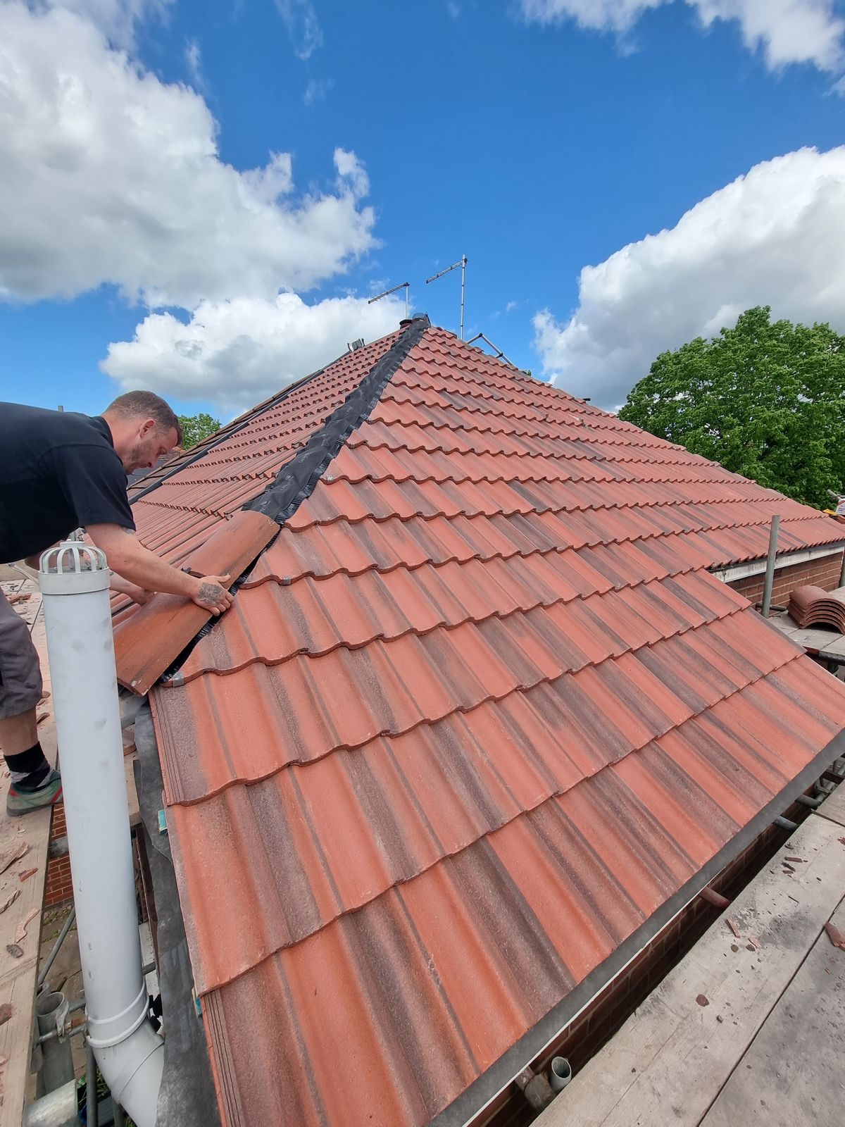 Newly laid red clay tile roof against a blue sky